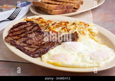 A view of a plate of steak and eggs breakfast. Stock Photo