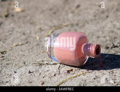 pink nail polish left on ground Stock Photo