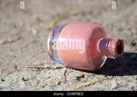 pink nail polish left on ground Stock Photo