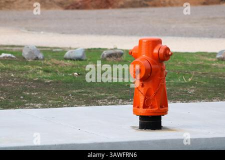 orange fire hydrant on sidewalk Stock Photo