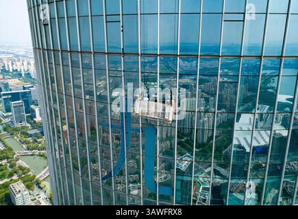 Suzhou, China - September 04, 2020: Window cleaners working on a high-rise building during a sunny day Stock Photo