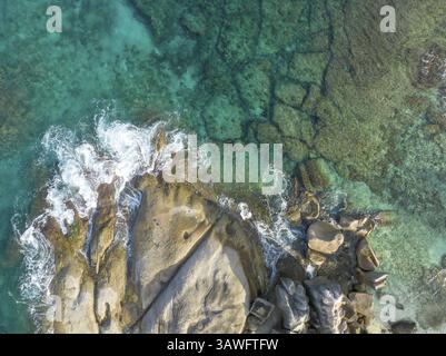 Aerial view of rocks in the sea with foaming waves in turquoise water, Aerial View, seychelles, Mahe, Port Glaud and Therese Island Stock Photo
