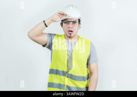 Surprised engineer looking into the distance isolated. Amazed latin engineer looking into the distance. Young engineer looking far away Stock Photo