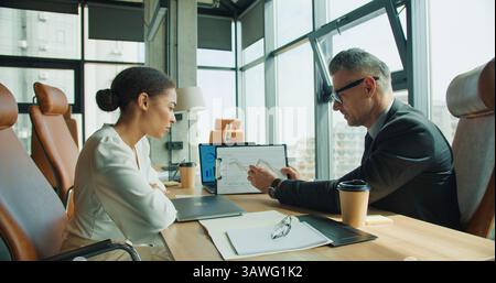 Colleagues analyzing sales trends in meeting Stock Photo