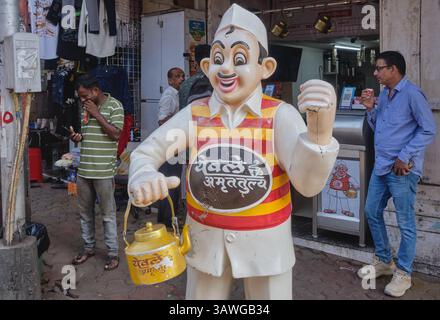 The trademark figure of an old-style Indian tea vendor standing outside of a branch of indian tea shop chain Yewale Amruttulya in Mumbai, India Stock Photo