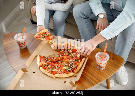 Colleagues eat pizza and chat. A snack break in the office. Business conversation of colleagues in a relaxed atmosphere Stock Photo