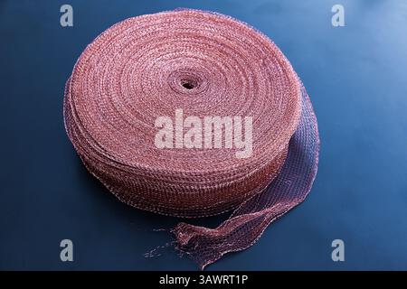 Copper mesh, twisted into a roll, close up. Twisted copper mesh. Stock Photo