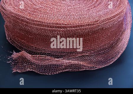 Copper mesh, twisted into a roll, close up. Twisted copper mesh. Stock Photo