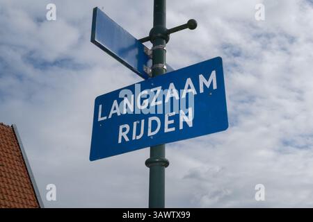 Dutch vintage slow down traffic sign on a street light. Stock Photo