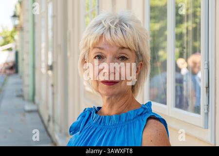 Portrait of a smiling middle-aged woman with short hair and make-up outdoors Stock Photo