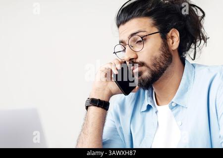 Busy Young Arab Businessman Talking On Cellphone And Working On Laptop Computer Stock Photo