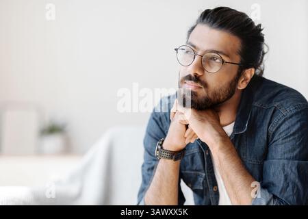 Portrait Of Thoughtful Millennial Arab Guy In Glasses Resting Head On Hands Stock Photo