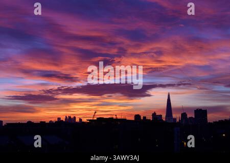 London skyline including the shard in silhouette with dramatic clouds at sunset Stock Photo