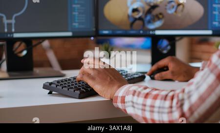 Male engineer designs 3D prototypes in a modern industrial interface using CAD software. Specialist creating gears and machinery tools via 3D modeling, technical expertise. Camera B. Stock Photo