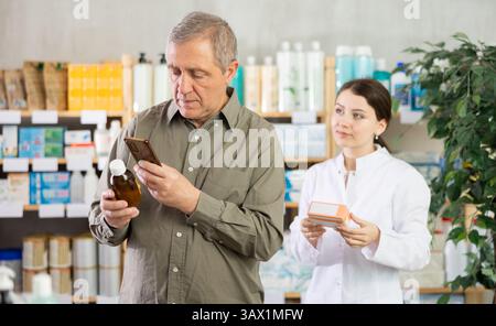 Man buyer scans syrup qr code with woman pharmacist Stock Photo