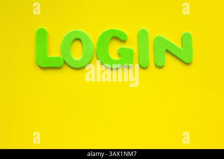 The word LOGIN made with green letters written on a yellow background with copy space. Stock Photo