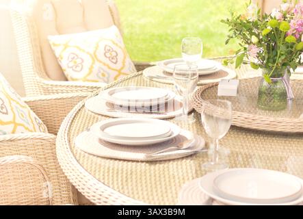Outdoor summer dining experience. Decorated open air party with fresh flowers and served tables. Stock Photo