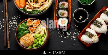 Assorted gourmet Japanese dishes. Set of sushi, rolls, soup and rice on a black background. Top view. Stock Photo