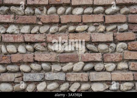 Horizontal pattern alternating with bricks and river stones - background Stock Photo