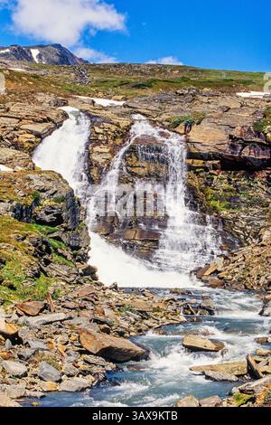 Waterfall on a rock in a mountain landscape Stock Photo
