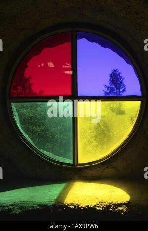 Old round window with four bright colours in an old building - coloured window Stock Photo