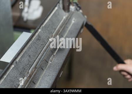Galvanised sheet metal is bent with a bending machine - close-up of metalworking Stock Photo