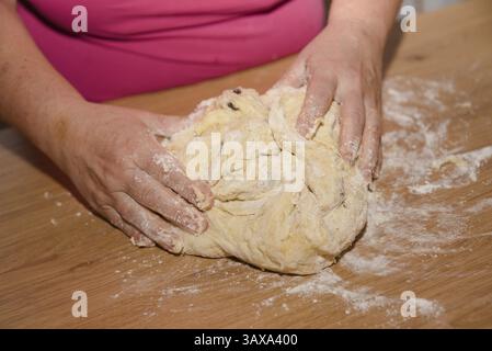 Pastry chef prepares yeast yeast dough in the bakery - Kneading dough Stock Photo
