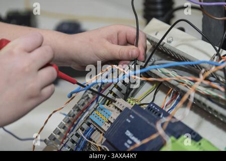 Electrical engineer working with a screwdriver on installations at the workplace - close-up Stock Photo
