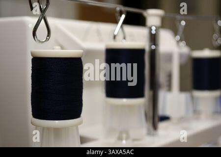 Black thread spools on sewing machine Stock Photo