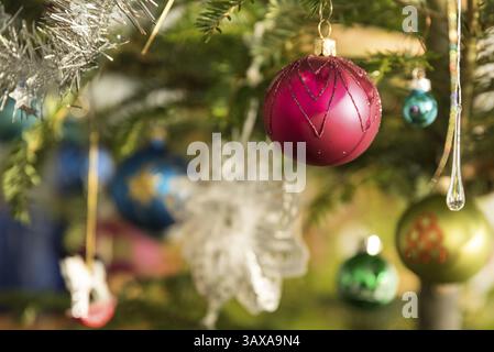 Christmas tree decorated with colourful Christmas baubles - close-up Christmas Eve Stock Photo