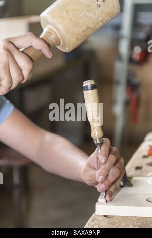 Working wood with a mallet and chisel - close-up of a carpenter's workstation Stock Photo