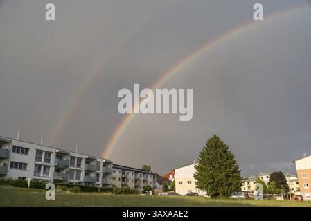Luminous double rainbow over flats in the countryside - thunderstorm Stock Photo