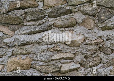 Masonry stone wall with old granite stones - close-up stone wall Stock Photo