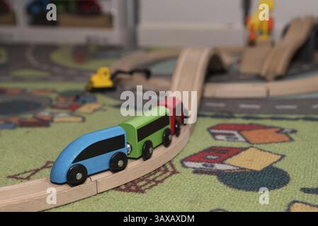 Colourful wooden toy train with tracks and toy carpet Stock Photo