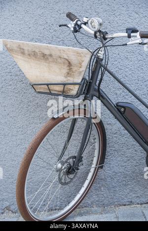 Wooden shopping basket on the front of the bike - E-bike with luggage rack Stock Photo