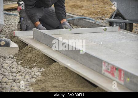Tiler laying tiles on a building site with spirit level Stock Photo
