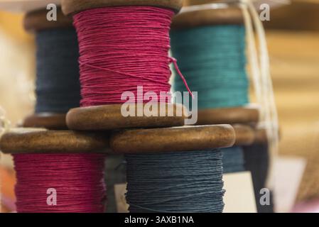 Coloured yarn wound onto wooden spools - thread and string Stock Photo