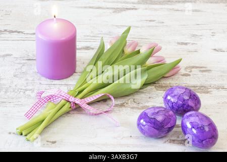 Bouquet of pink tulips with candle and Easter eggs on rustic wooden background Bunch of pink tulips with candle and Easter eggs on rustic wooden backg Stock Photo