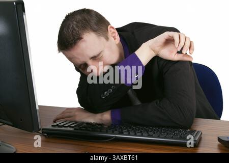 Young businessman falling asleep at his desk - Freisteller Young businessman falling asleep at his desk - isolated Stock Photo