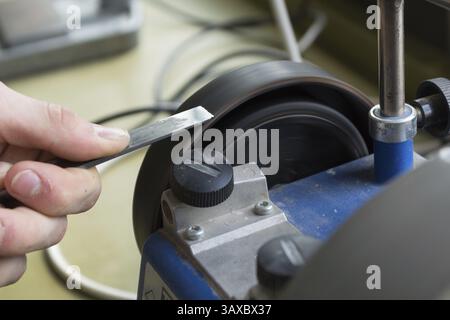 Sharpening chisels with a wet grinder, Austria, Europe Stock Photo