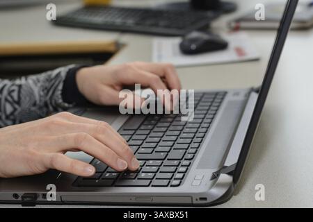 Office clerk working on a laptop - close-up Stock Photo