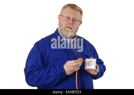 Electrician inserts orange plug into a socket - optional Stock Photo