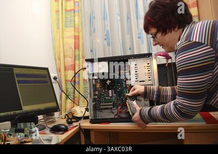 IT technician replaces the graphics card of a PC Stock Photo