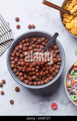 Breakfast chocolate balls with milk in bowl on a white background, top view. Stock Photo