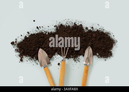 Concept season work and hobby. Various hand wooden tools and soil on blue background. Spring gardening. Top view. Copy space. Stock Photo