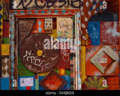 Vivid Artistic Graffiti on Colorful Wooden Panels with Metal Accents, Metelkova, Ljubliana, Slovenia Stock Photo