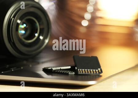 SD memory cards, laptop and photo camera on table, closeup Stock Photo