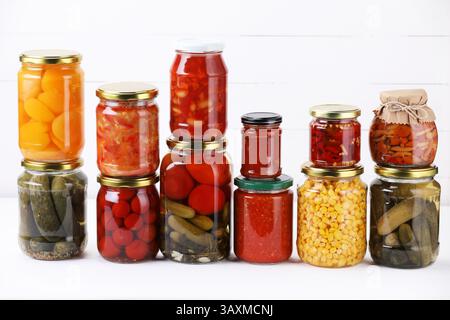Many jars with different pickled products on white table Stock Photo