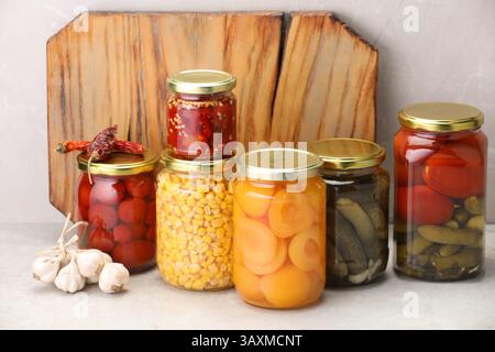 Many jars with different pickled products on light table Stock Photo