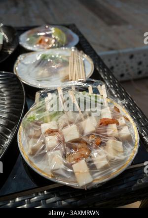 street food under transparent packaging on the street on the table Stock Photo